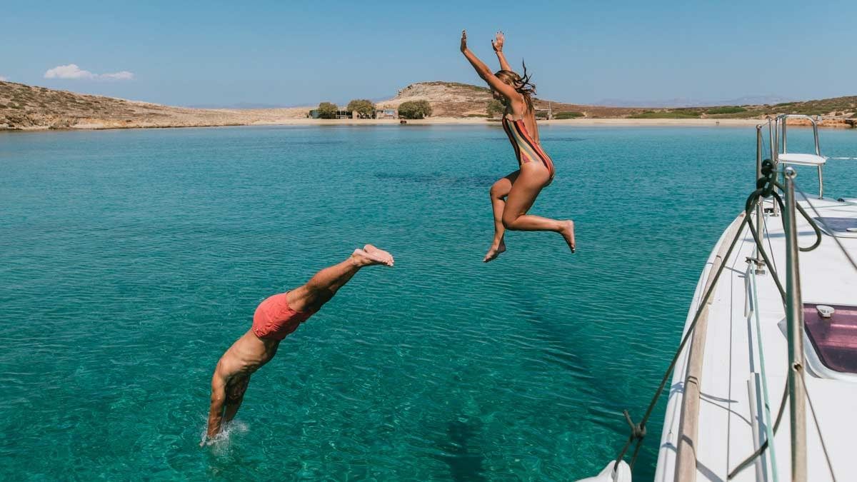 Guests jump into the sea from their yacht