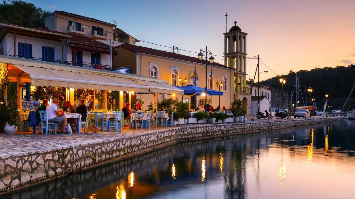 Image of waterfront restaurants at sunset in Vathy, Meganisi.