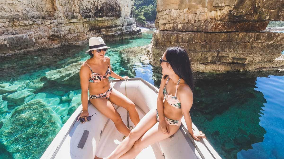 Two friends exploring the blue caves in Corfu by boat