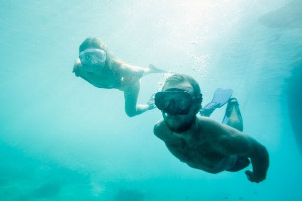 Couple snorkel under water in Croatia