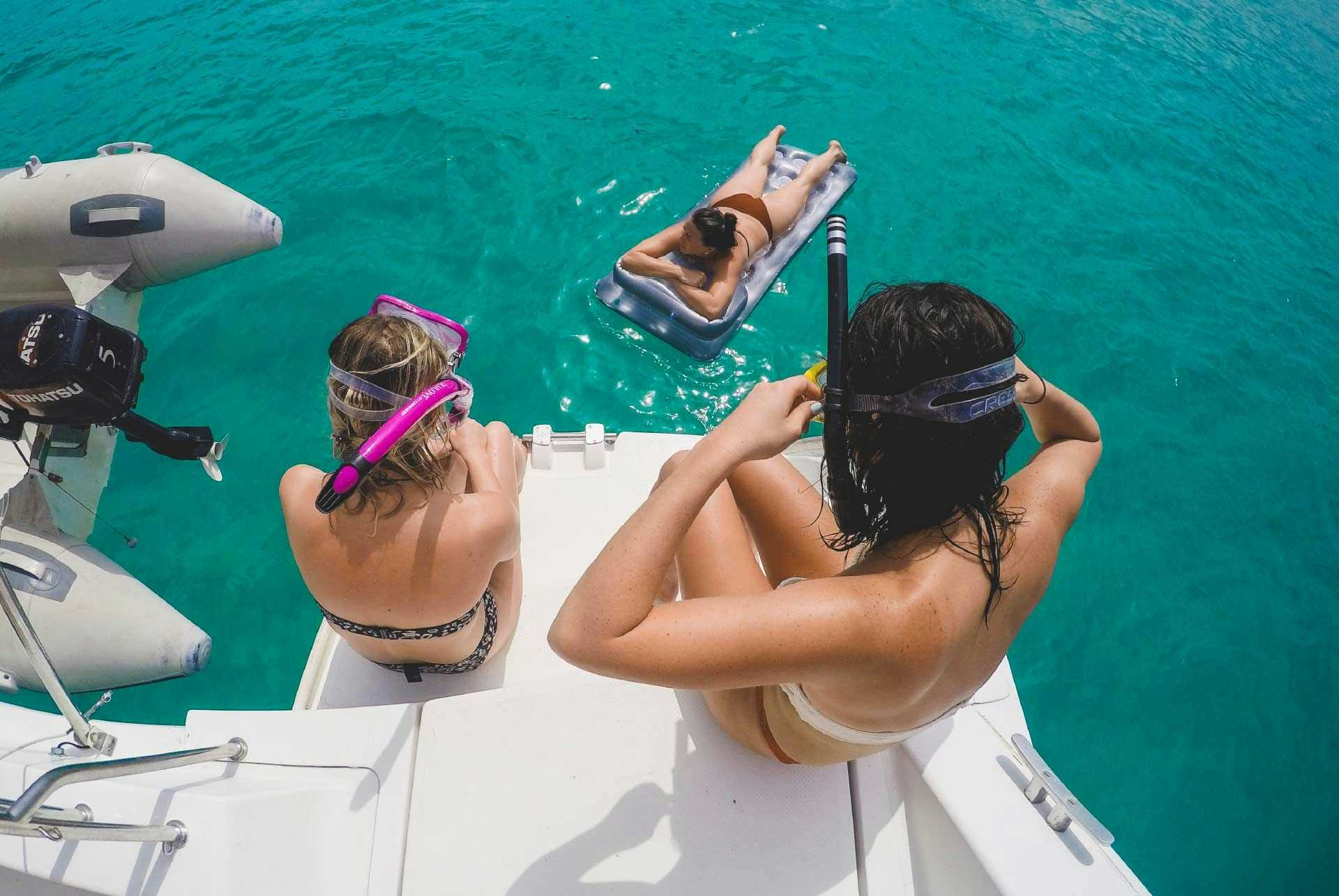 Two women on a yacht about to go snorkelling