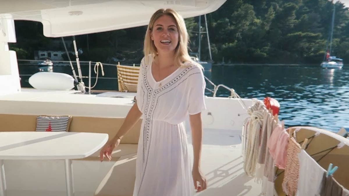 Woman walking around the stern of a Yacht Getaways catamaran