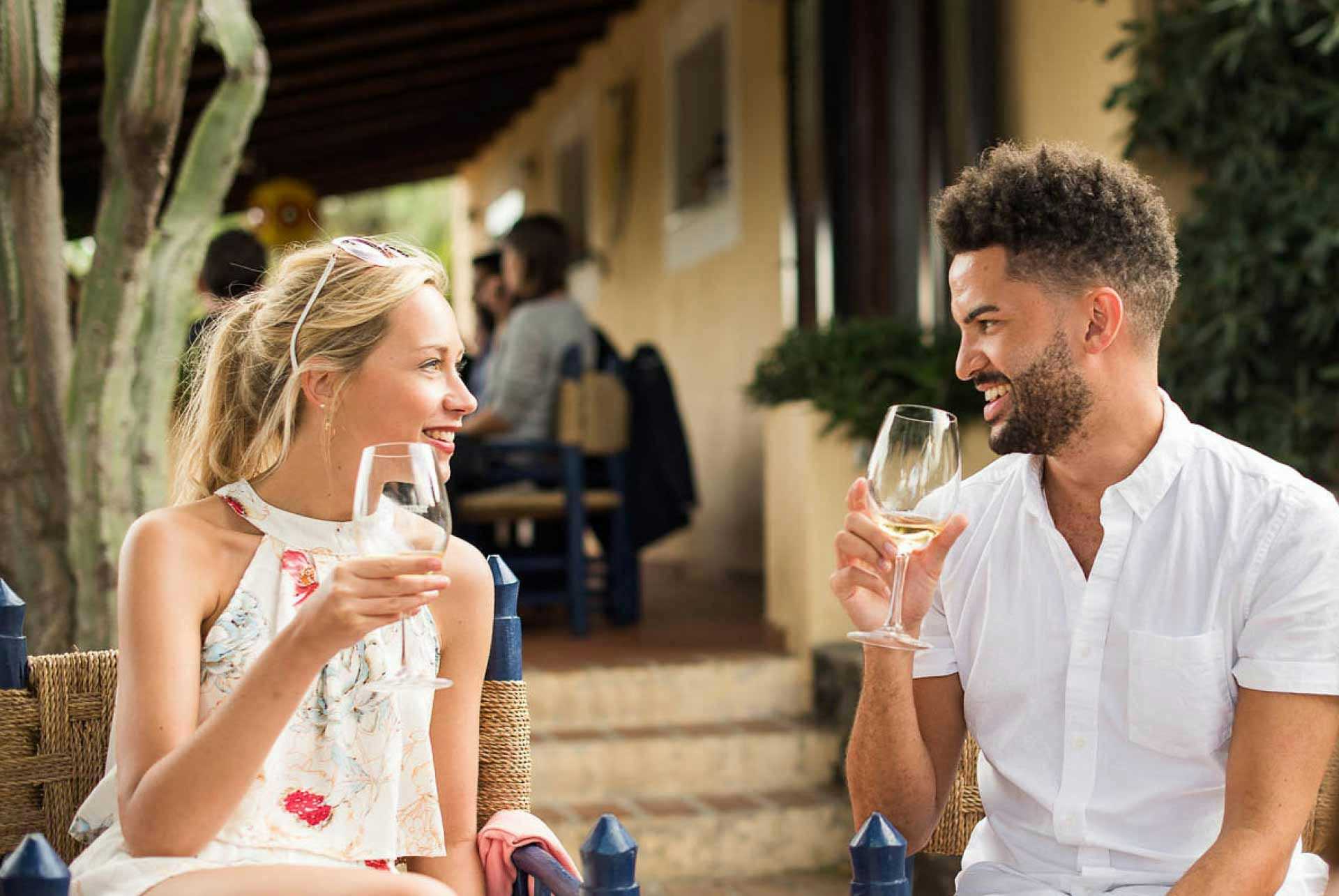 Couple tasting some white wine at a vineyard in Salina