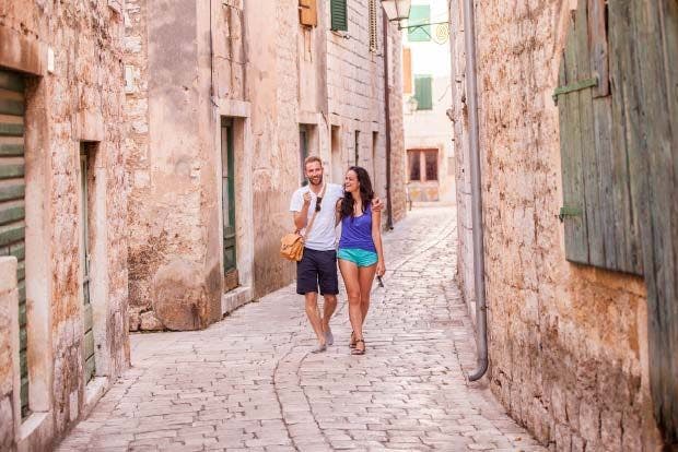 Couple walking cobbled streets of Stari Grad in Croatia