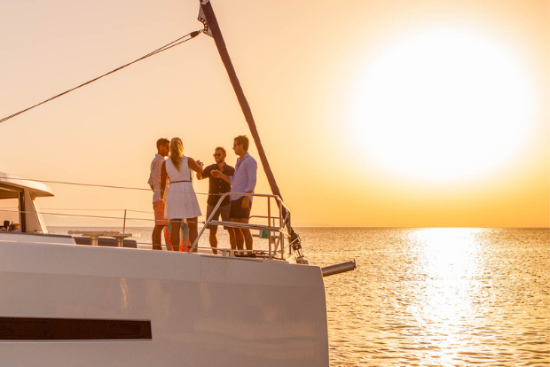 Group of people having sunset drinks on a yacht
