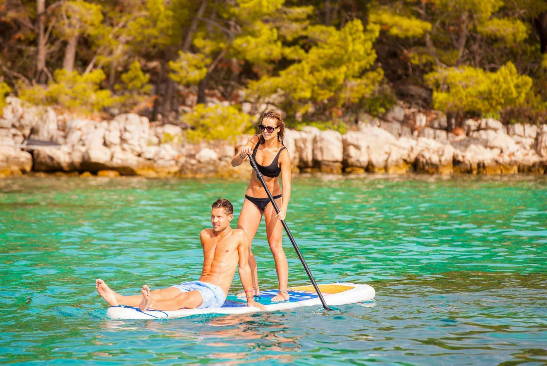 Couple paddleboarding in Greece
