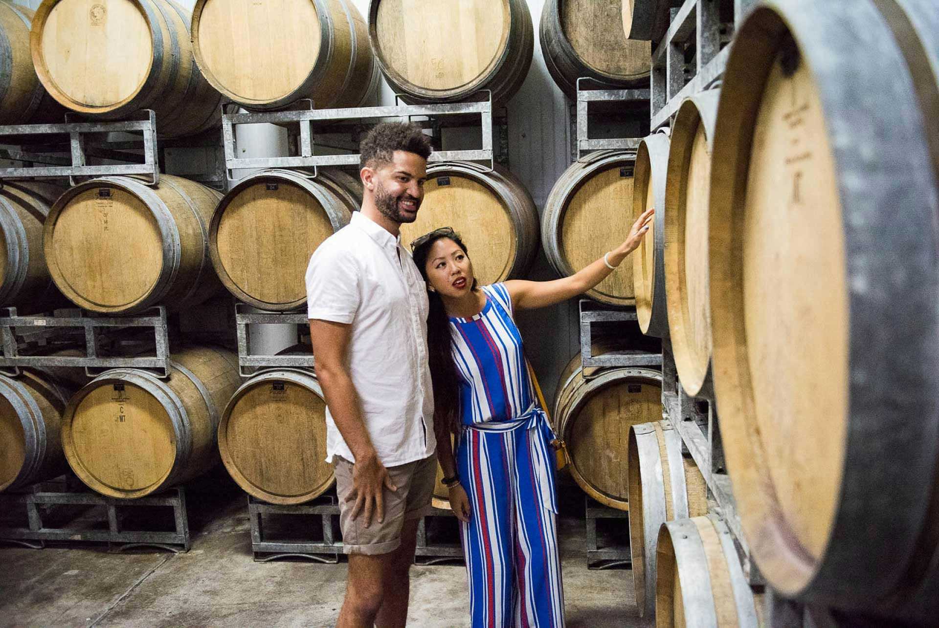 Couple looking at barrels in a wine cellar