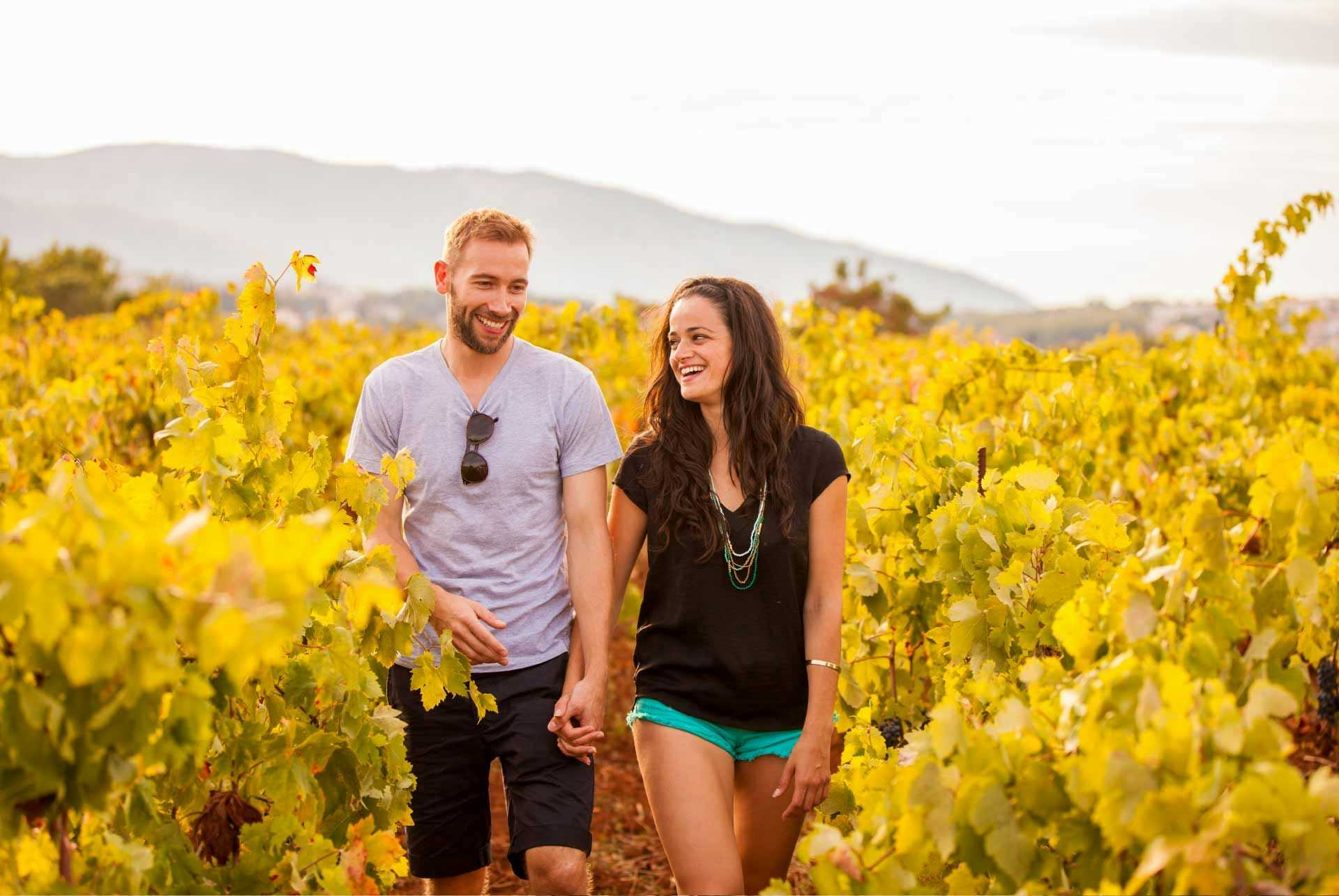 Couple walk through the vines at Hora Farm Winery