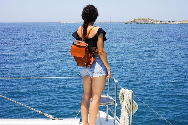 Woman on yacht bow wearing a leather backpack